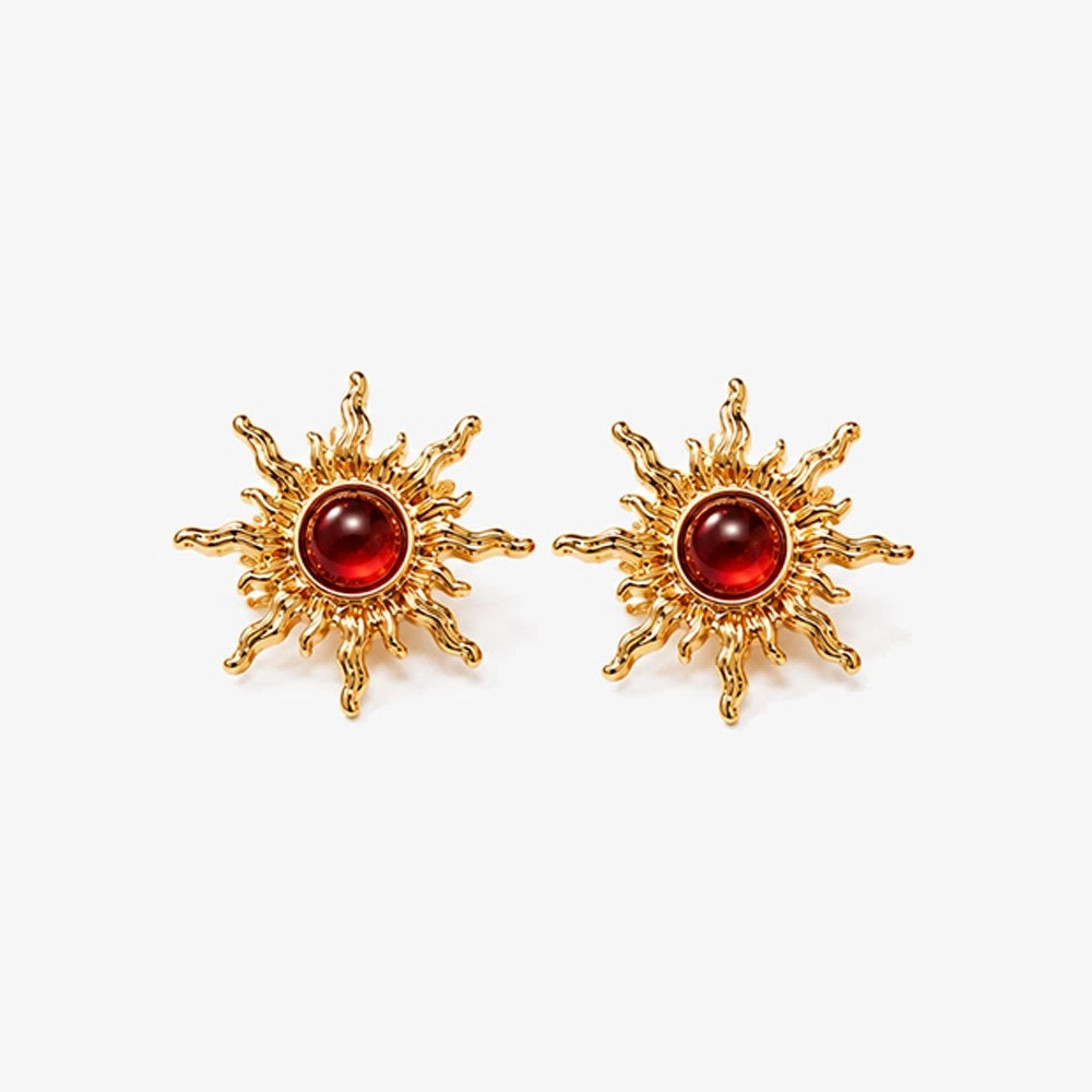 Gold sun clip-on ear studs with red faux rubies adding fiery power.