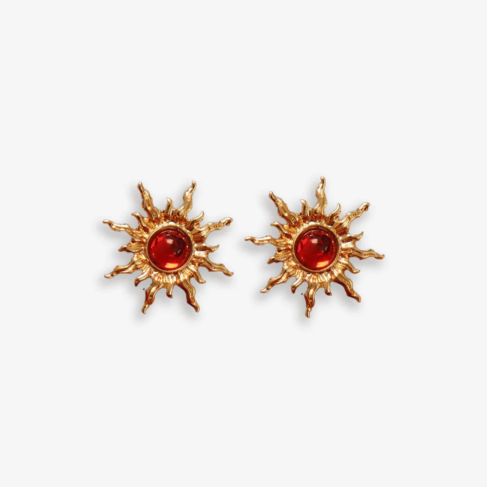 Gold sun clip-on ear studs with red faux rubies adding fiery power.
