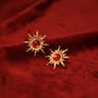 Gold Sun Clip-On Earrings with Ruby displayed on red velvet fabric, showing detailed front view of the sun-shaped design with red gemstone centers