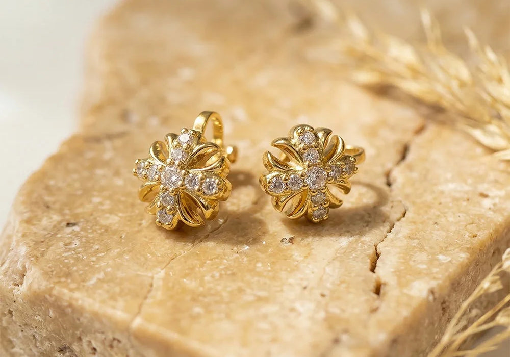 Gold Cross Clip-On Stud Earrings displayed on natural stone, showing detailed front view with diamond accents