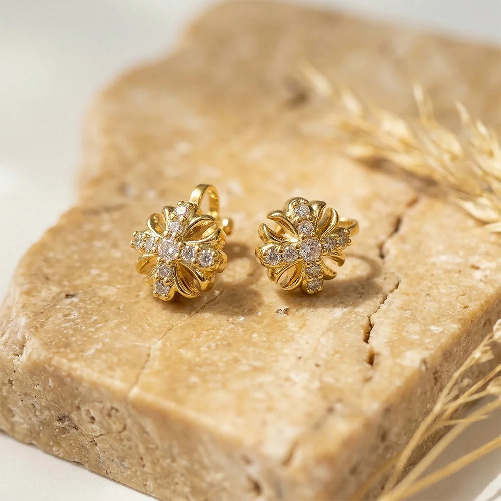 Gold Cross Clip-On Stud Earrings displayed on natural stone, showing detailed front view with diamond accents