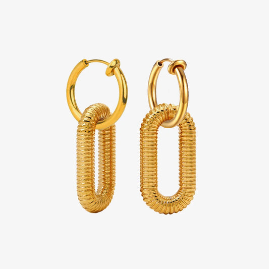 Pair of Golden Spiral Clip-On Dangle Hoop Earrings displayed on a white surface, capturing the elegant and modern design.