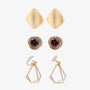 A set of three clip-on earrings. The earrings feature a gold color with one earring having a square shape, and the other two earrings having a geometric layered design.
