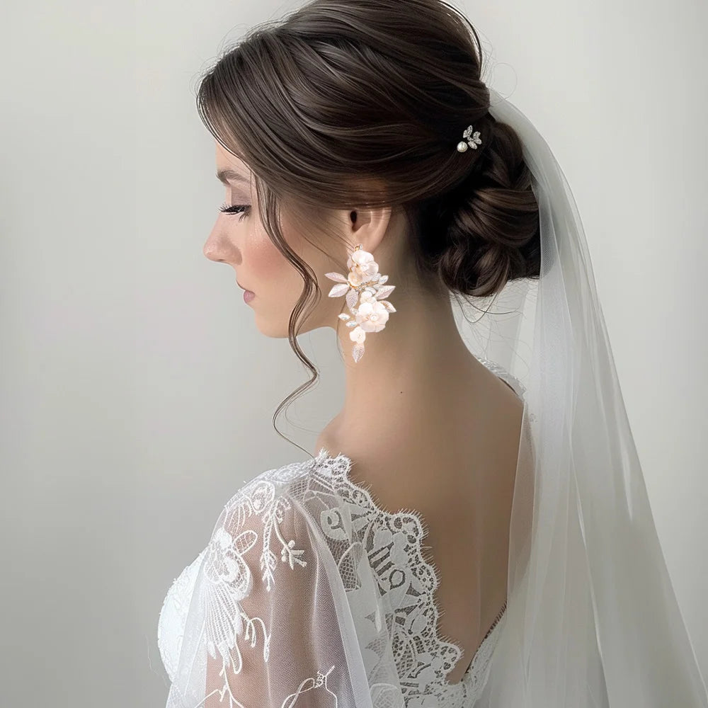 Golden Leaf & Blossom Clip-On Earrings with Pearls worn on bride in profile view with white lace wedding dress and veil
