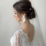 Golden Leaf & Blossom Clip-On Earrings with Pearls worn on bride in profile view with white lace wedding dress and veil