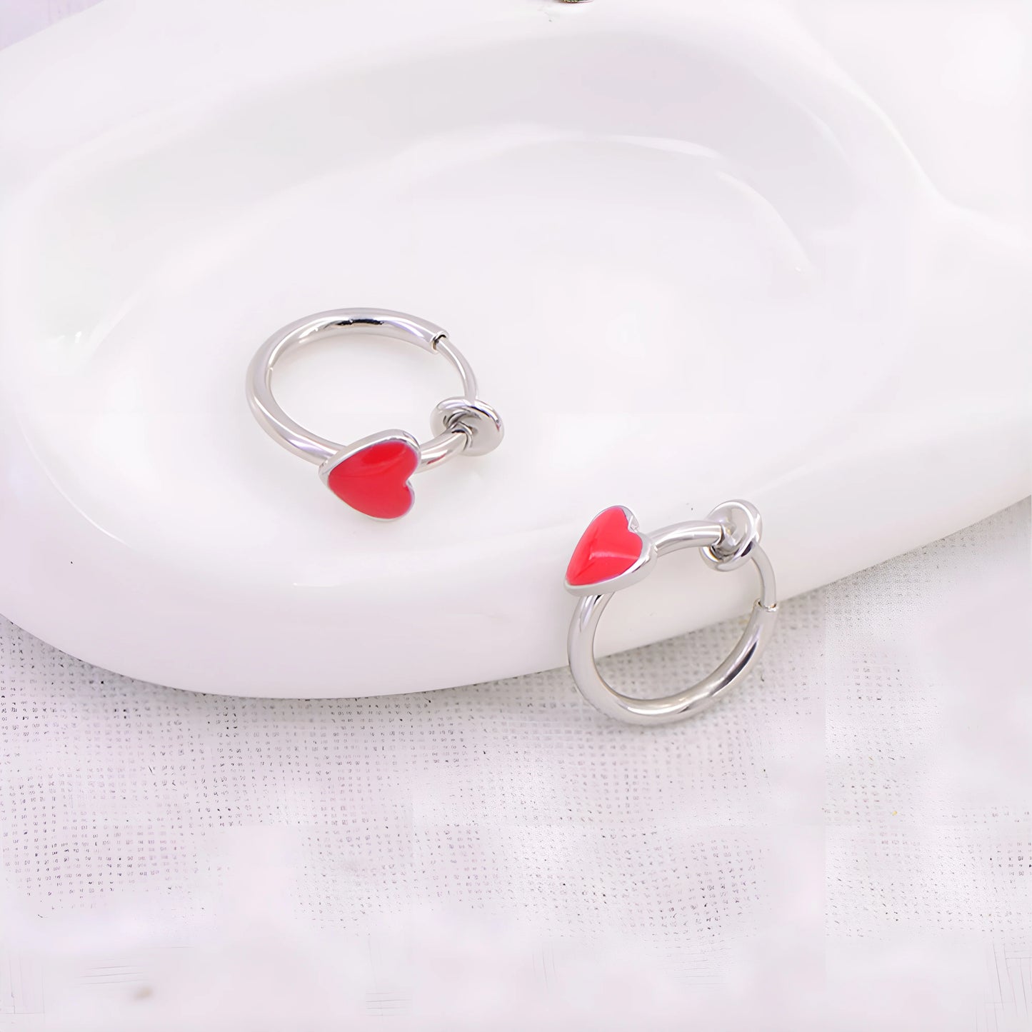 Women's fake earrings in silver with a charming heart design, perfect for everyday wear.