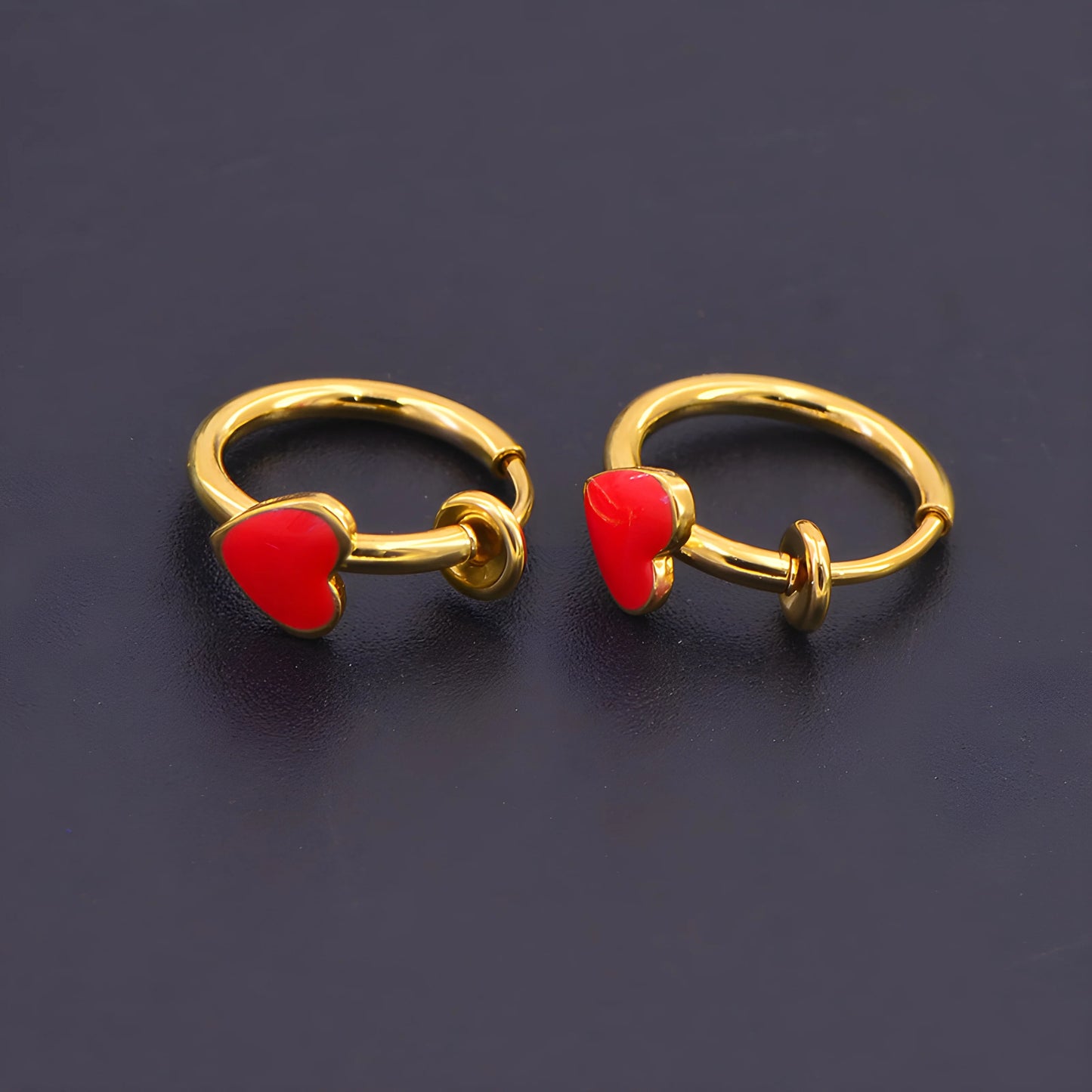 Close-up of sliding spring-ring clip-on design on gold heart hoop earrings.