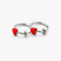 Two silver-toned hoop earrings, each featuring a small red heart charm, displayed on a clean white background.