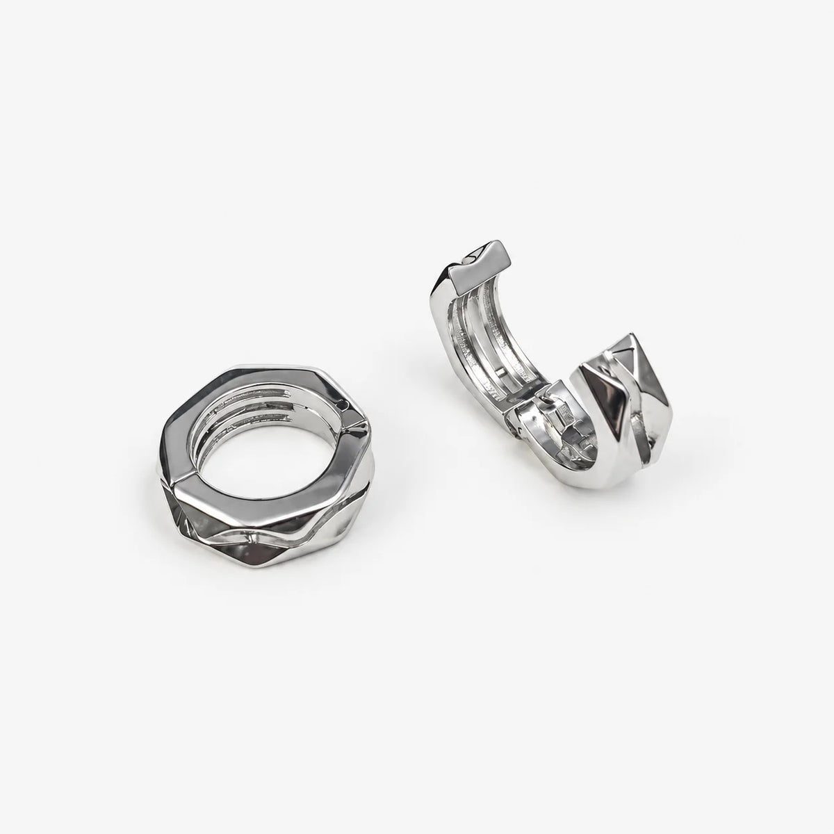 Two silver-toned metal ear cuffs shown on a clean white background, one displaying the threaded inner opening and the other showing the outer crimped closure.