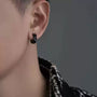 Black hex cut clip-on hoop earrings side view worn on model against gray background