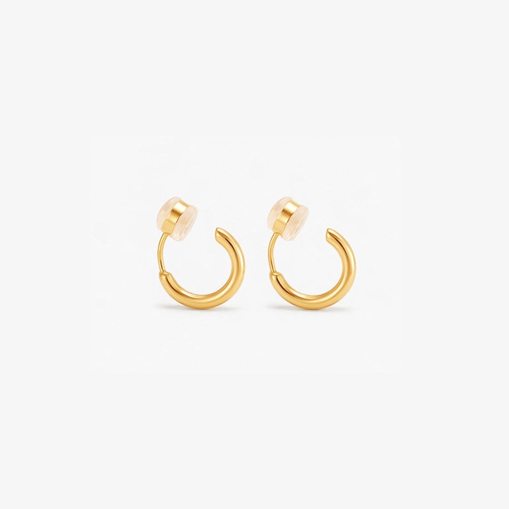 A pair of gold-colored clip-on huggie hoop earrings with a sleek, classic design.