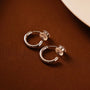 Showcase of Huggie Hoop Clip-On Earrings in White Gold, highlighting the sleek and elegant finish.