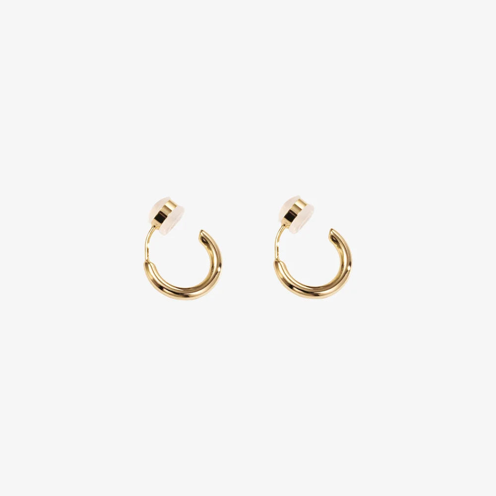 A pair of gold-colored clip-on huggie hoop earrings with a sleek, classic design.
