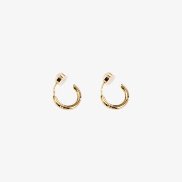 A pair of gold-colored clip-on huggie hoop earrings with a sleek, classic design.