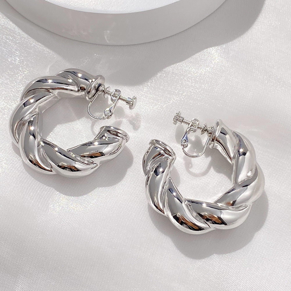 The Silver Bold Twist Hoop Clip-On Earrings feature a modern, twisted design, made from high-quality alloy with a screw-back closure ensuring a comfortable fit for all-day wear. Perfect for enhancing your work attire with a touch of sophistication.