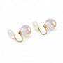 A pair of clip earrings with large, oval, iridescent pearl-like beads on a clean white background.