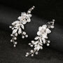 Ivory Bloom Pearl Clip-On Earrings with silver flowers and dangling pearls, displayed on black background