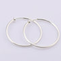 Silver large hoop clip-on earrings displayed overlapping on white background showing polished metallic finish