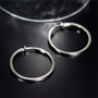 Silver large square tube clip-on hoop earrings displayed on dark background showing polished metal finish and classic design