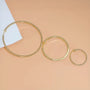 Gold square tube clip-on hoop earrings in three sizes displayed on neutral beige background