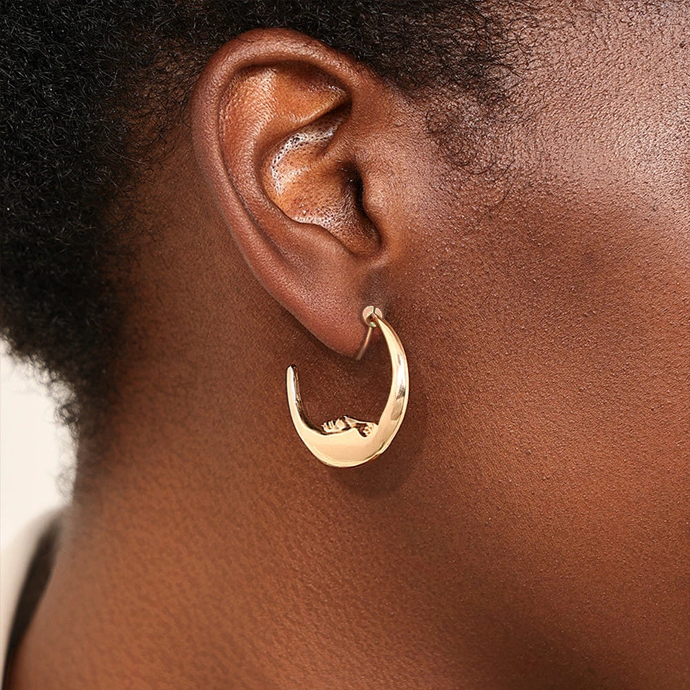 Lunar Face Gold Rotating Clip-On Earrings worn by a model, emphasizing their bold statement design.