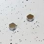 Polygon Magnetic Stud Earrings in Silver displayed at angle on white speckled background showing metallic finish and geometric shape