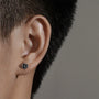 Metallic windmill magnetic stud earrings with black zirconia shown on ear, side view against gray background