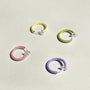 Mini Glow Clip-On Hoop Earrings in green, pink, yellow and purple displayed on white background