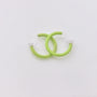 Mini Glow Clip-On Hoop Earrings in green, displayed at an angle on a white background showing the luminous curved design and clear clips
