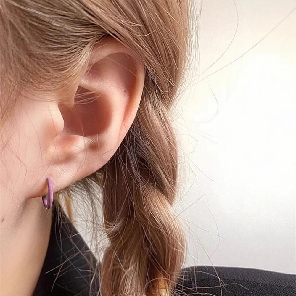 Mini Glow Clip-On Hoop Earrings in pink, side profile view worn on ear, demonstrating fit and luminous finish
