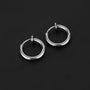 Silver mini hoop clip on earrings angled view on dark background showcasing polished metallic finish