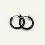Black mini hoop clip-on earrings with silver-tone findings displayed on white background