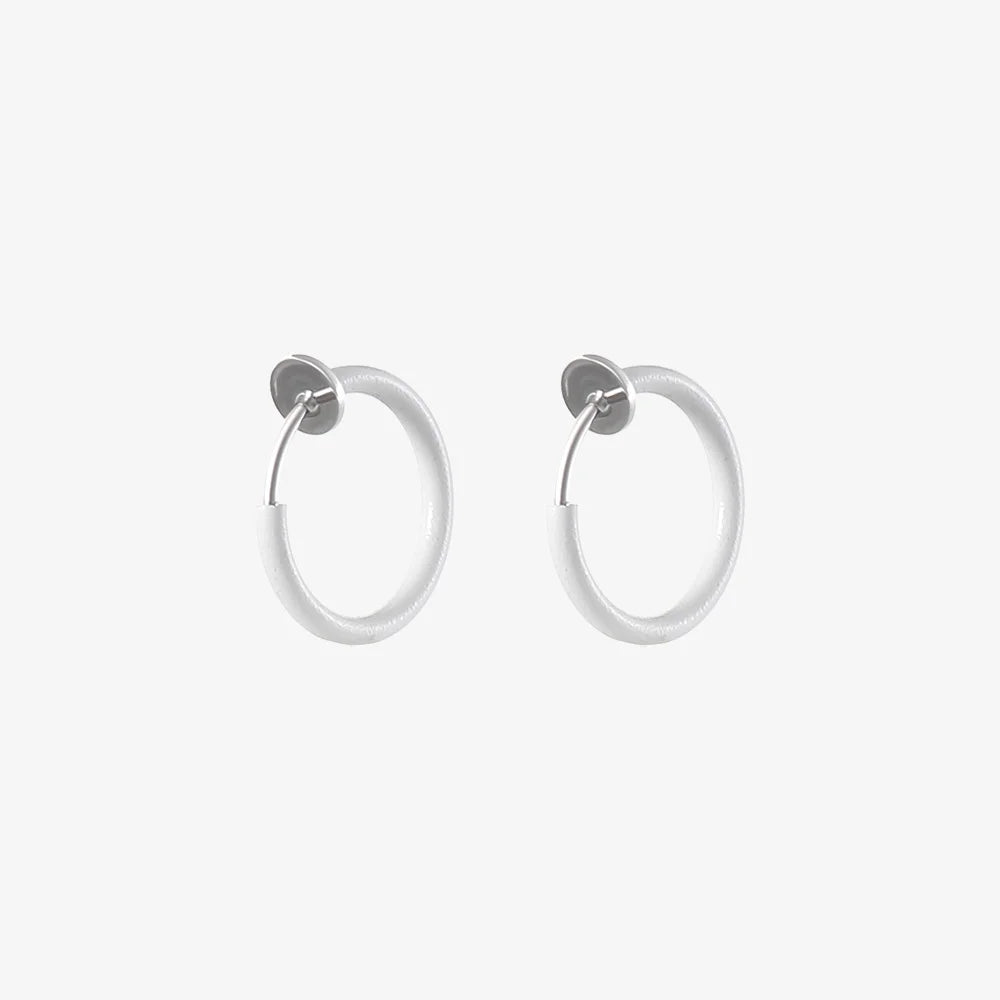 White mini hoop clip-on earrings front view on light background, showing pair of circular earrings with metallic posts
