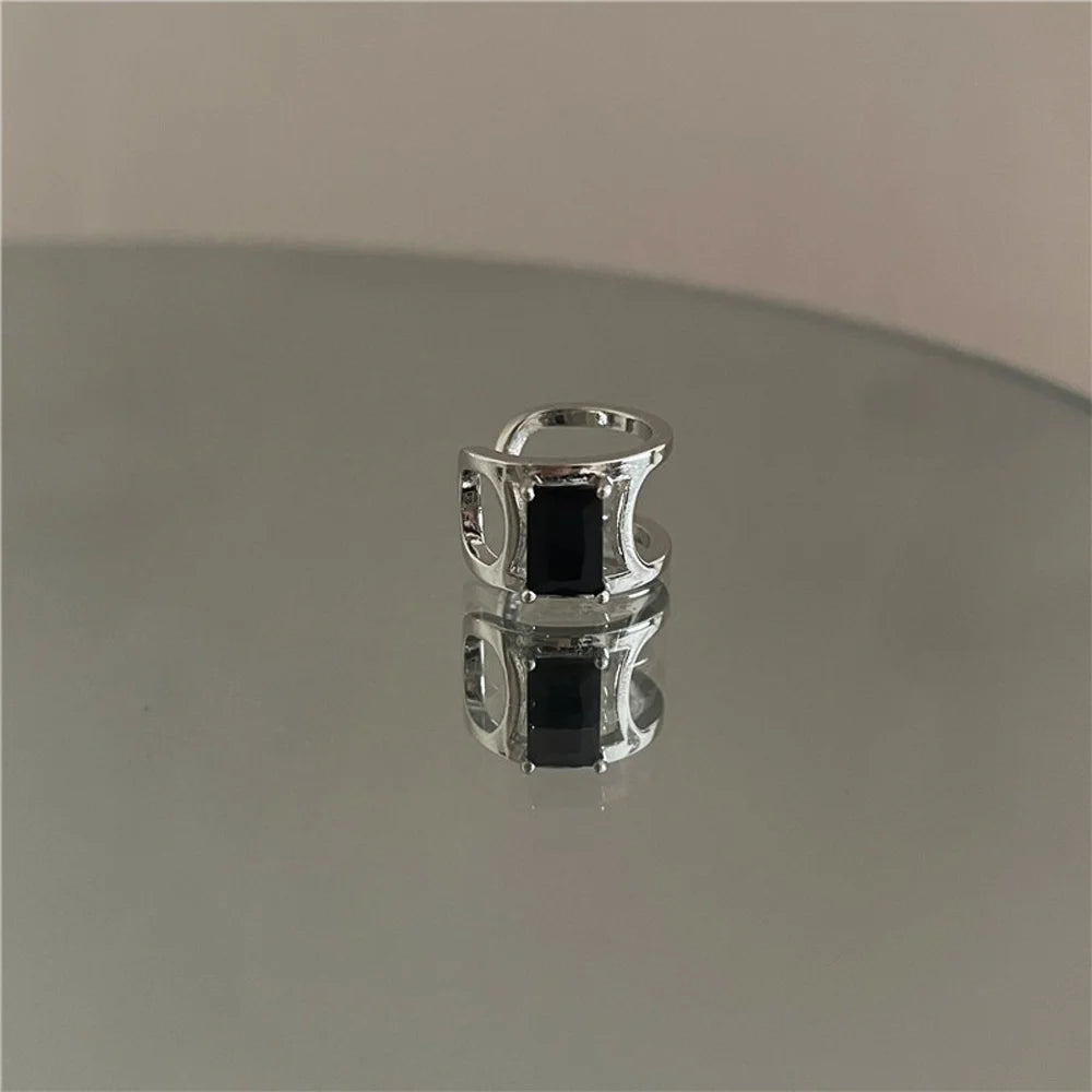 Minimalist Black Zircon Band Ear Cuff displayed on a reflective surface.