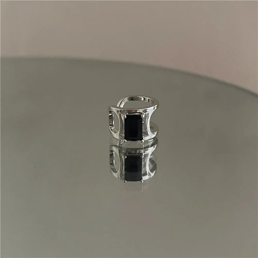 Minimalist Black Zircon Band Ear Cuff displayed on a reflective surface.