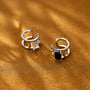 Minimalist white zirconia band ear cuff pair displayed on gold surface showing silver metal design with crystal stone detail