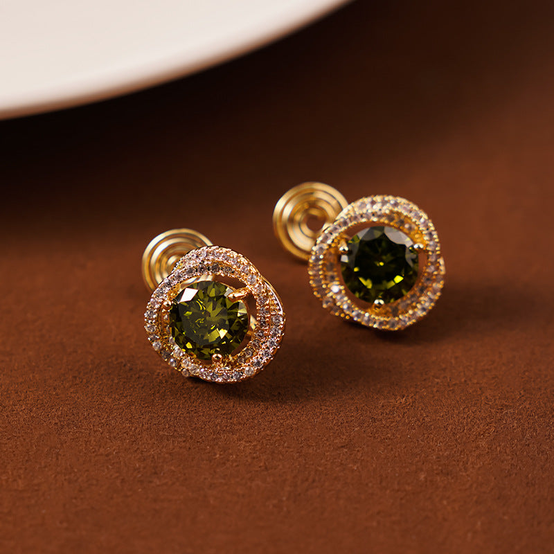 Elegant clip-on earrings featuring a deep green emerald zircon and white zircon stones.