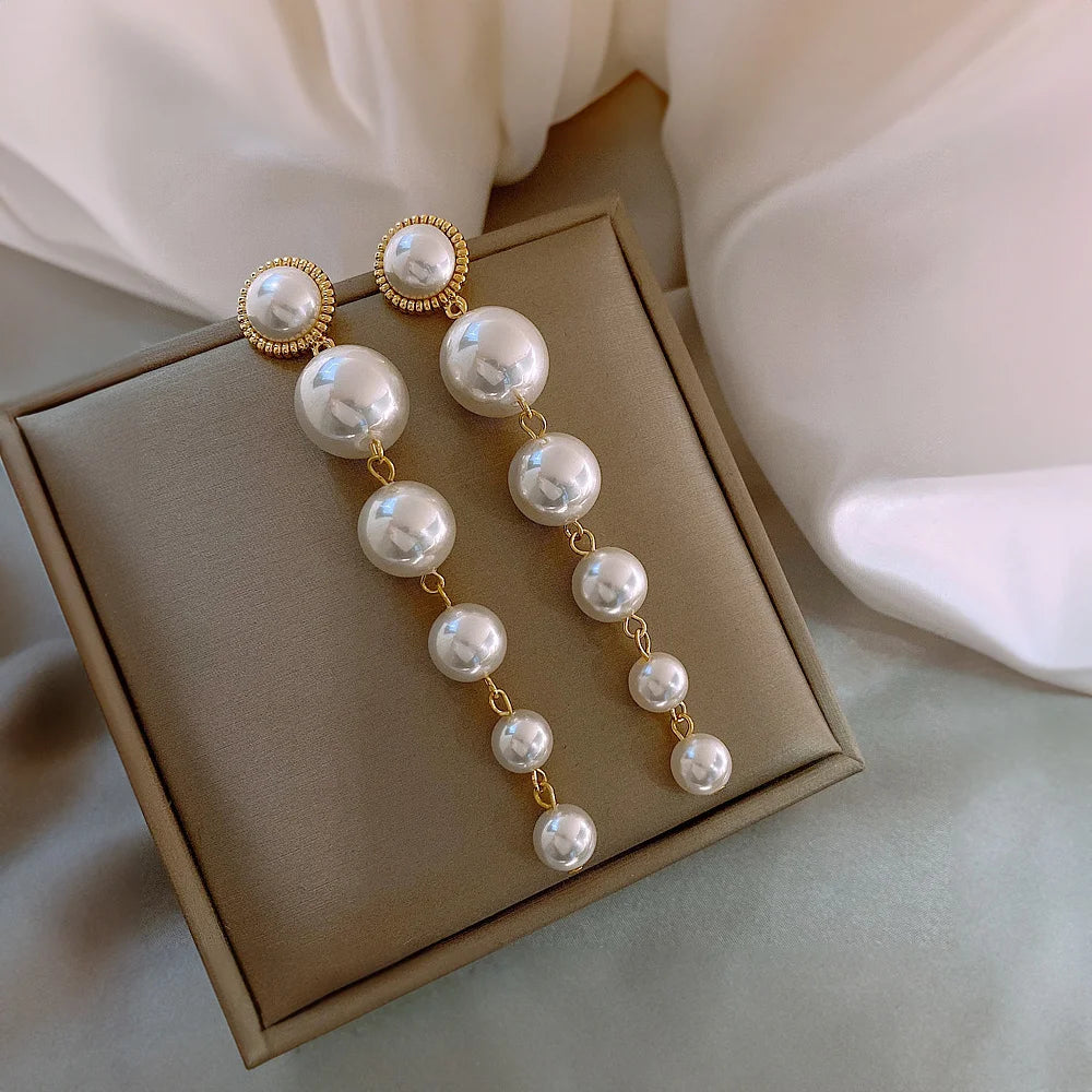 Elegant clip on pearl earrings with cascading faux pearls from large to small.