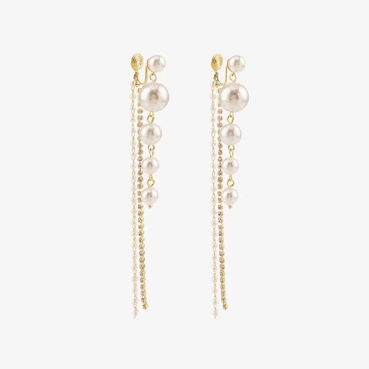 Pair of Pearl Cascade Clip-On Earrings displayed on a soft beige surface, capturing the elegant and dramatic design.