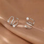 Pearl and Zirconia Double-Band Silver Ear Cuffs displayed on beige fabric, angled view showcasing sparkling details