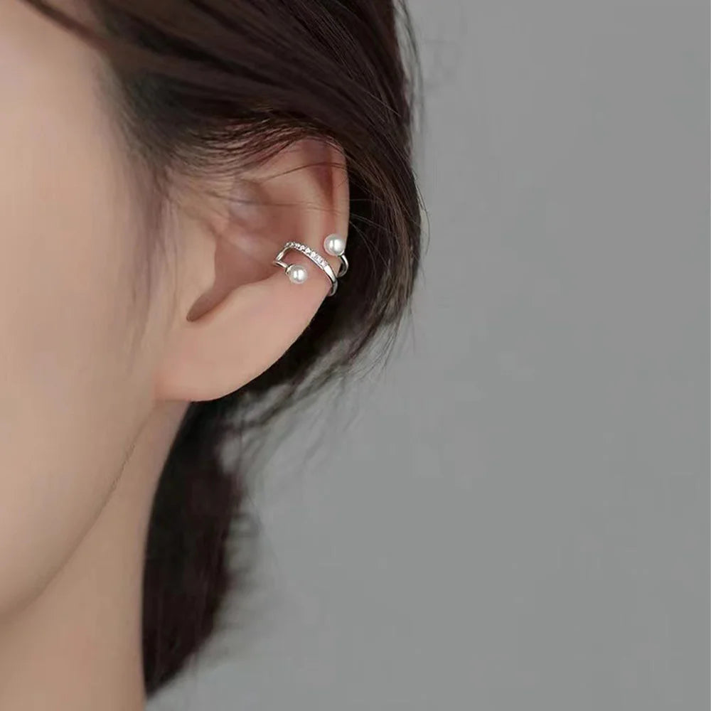 Pearl and zirconia double-band silver ear cuffs side view worn on ear with gray background