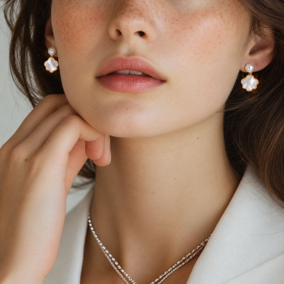 Genuine pearl and shell clip-on earrings worn on model, front angle view with neutral background