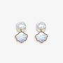 Paire de boucles d'oreilles à clip en perles et coquillages présentées sur une surface blanche douce, mettant en valeur leur design raffiné et leurs matériaux luxueux.