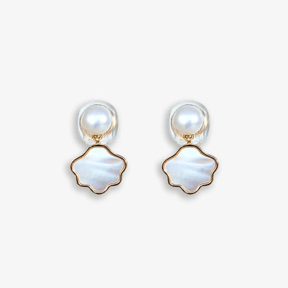 Pair of Pearl and Shell Clip-On Earrings displayed on a soft white surface, capturing the refined design and luxurious materials.