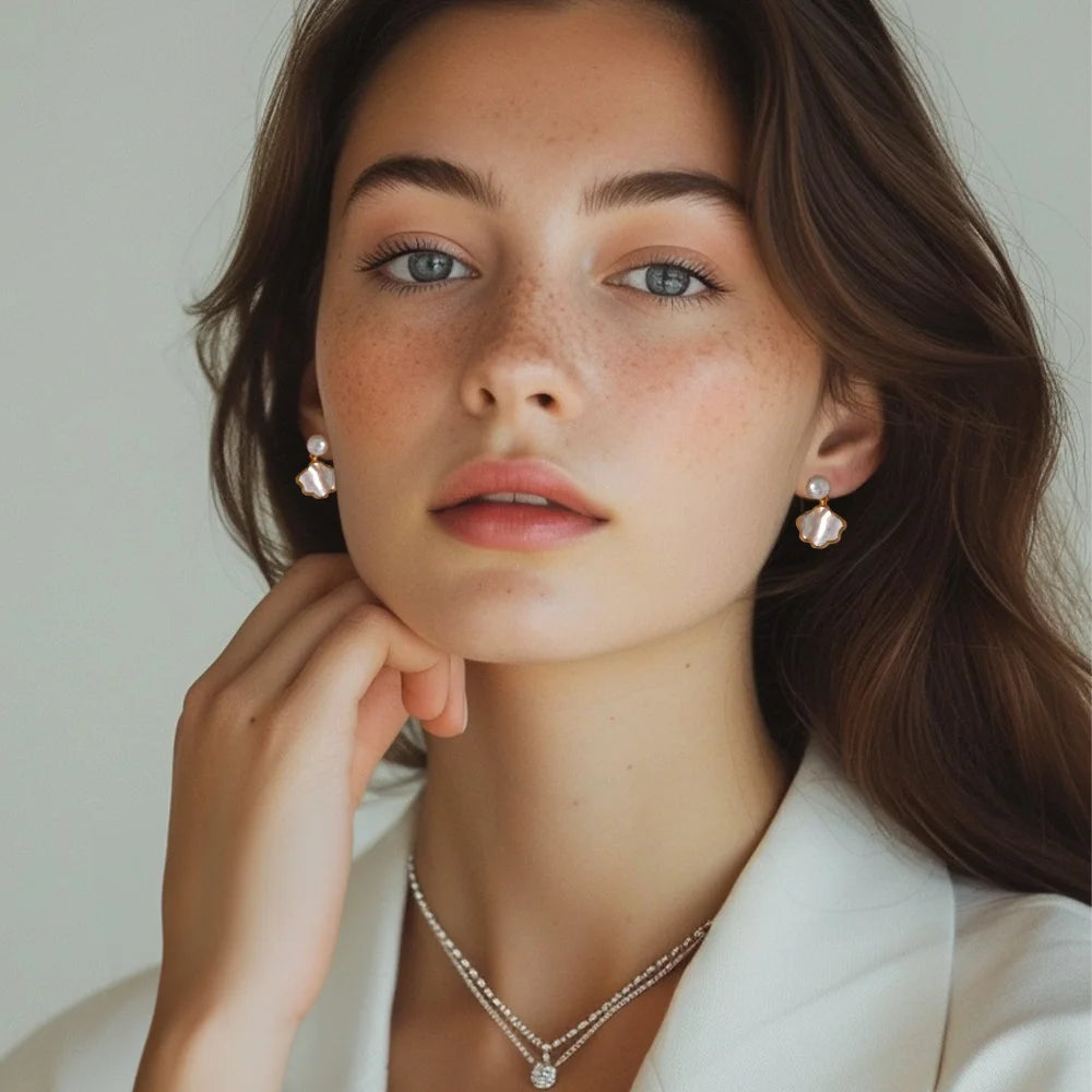 Genuine pearl and shell clip-on earrings worn on model, front angle view with neutral background