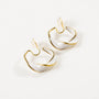 Pearlescent Wave Clip-On Hoop Earrings in gold and iridescent white, angled view