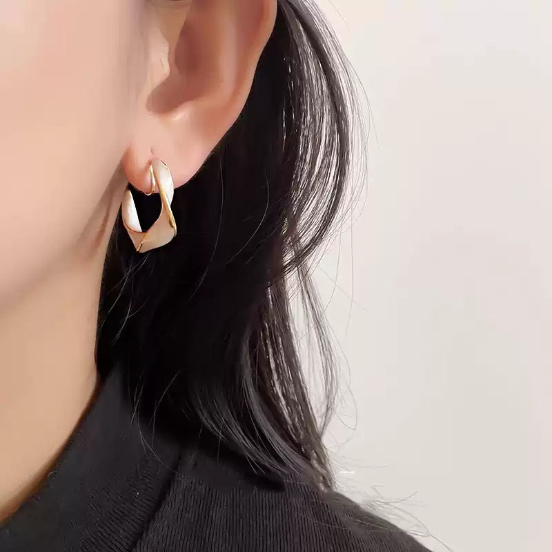 Pearlescent Wave Clip-On Hoop Earrings side view on model with black hair showing pearl and gold finish detail