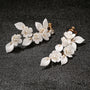 Petal Pearl Cascade clip-on earrings with white flower petals and pearl details, displayed on dark background