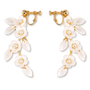 A pair of gold-tone drop earrings featuring white enamel flowers with pearl centers and leaf-shaped enamel details, shown on a plain white background.