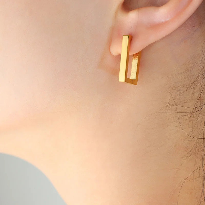 Gold rectangle clip on hoop earrings side view worn on ear, geometric design